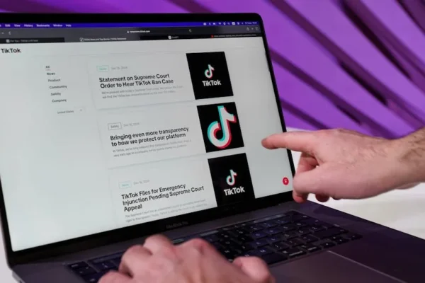 Close-up of a person interacting with TikTok content on a laptop indoors.