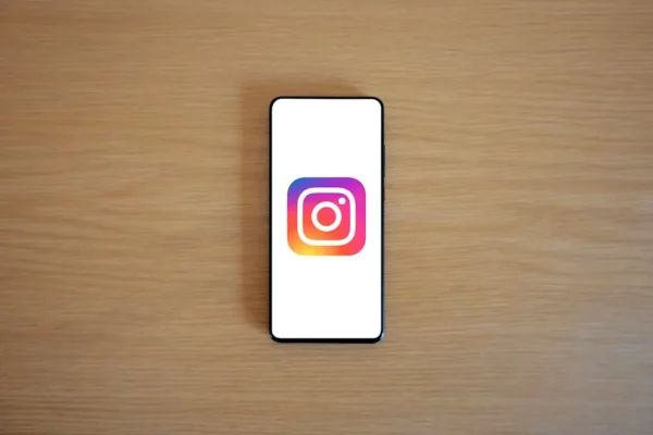 A smartphone with the Instagram logo on display, placed on a wooden surface. Perfect for technology and social media themes.