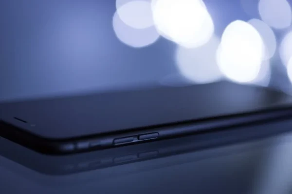 Close-up shot of a sleek smartphone with a blurred bokeh background, emphasizing its modern design.