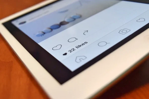 Photo of a tablet displaying a social media app interface with 22 likes, highlighting digital interaction.